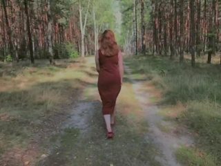 Žaismingas raudonplaukiai šlapinimasis į miškas ir rodantis jos didelis krūtys