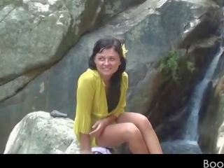 Amateur teen seductress working her lusty twat by a waterfall