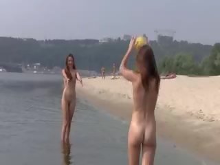 Nakal muda nudists bermain dengan masing-masing lain di sand